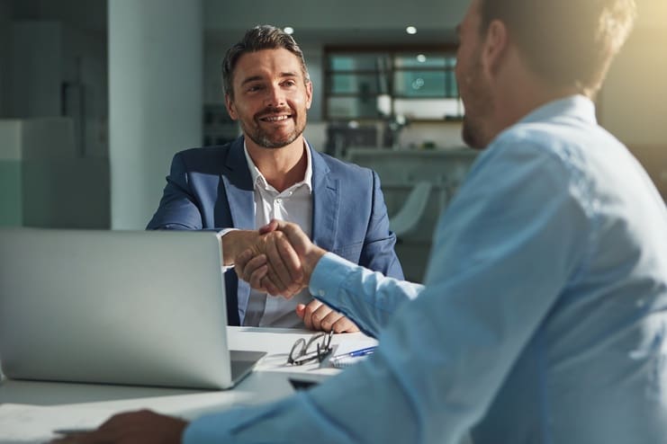 Two men shaking hands in a meeting