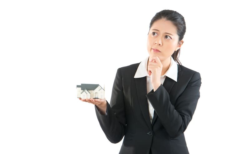 An office woman holding a mini model house